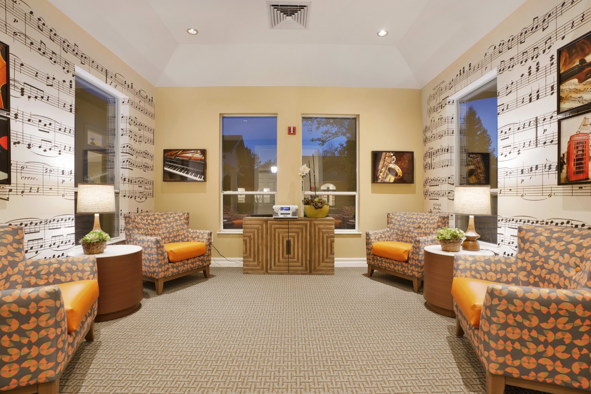 A cozy living room with two armchairs, side tables, and warm lighting.
