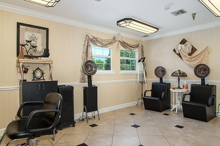 A cozy salon interior with chairs and hairdryers, featuring elegant decor and natural lighting.