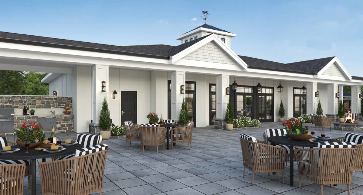 A modern outdoor patio with wicker seating and decorative plants.