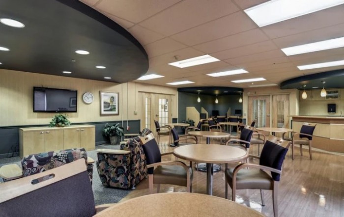 A modern waiting area featuring comfortable seating and tables.