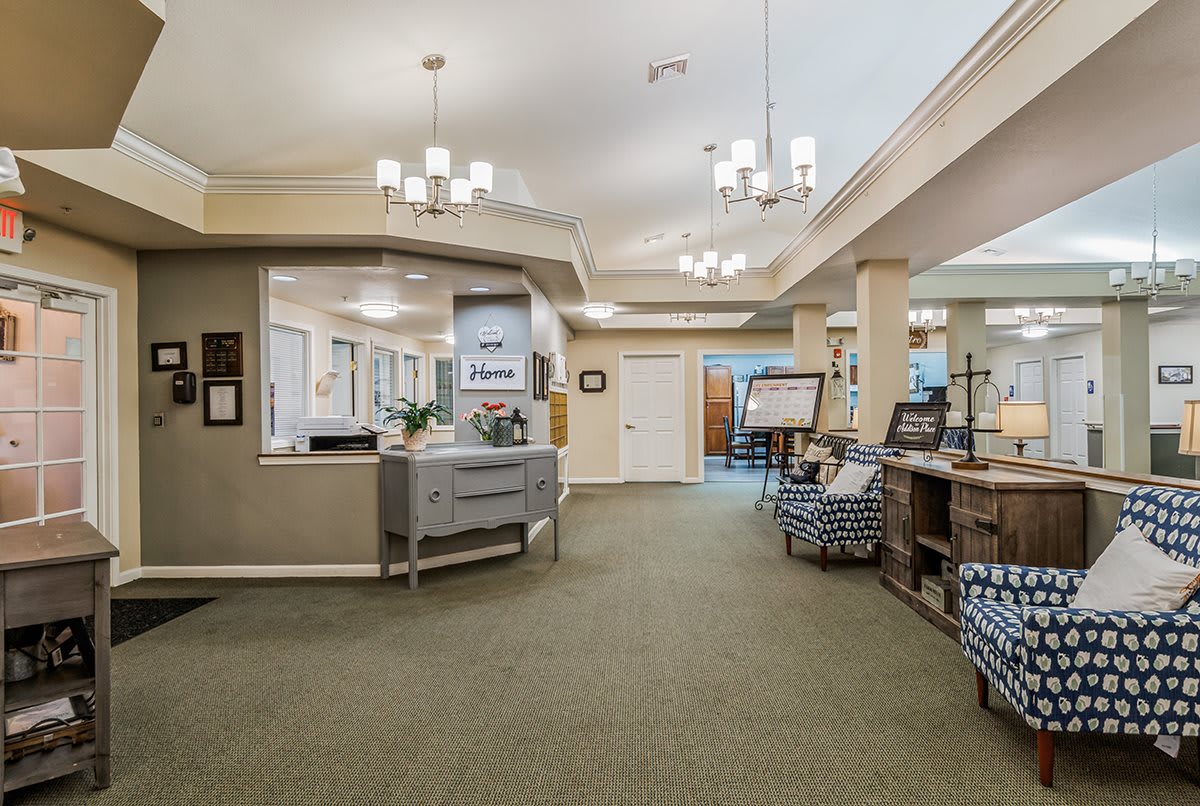 A spacious and well-lit reception area featuring modern chandeliers, comfortable seating, and a welcoming ambiance.