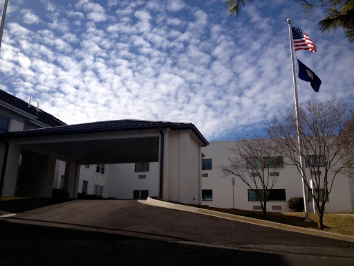A view of a building with flags flying under a cloudy sky.