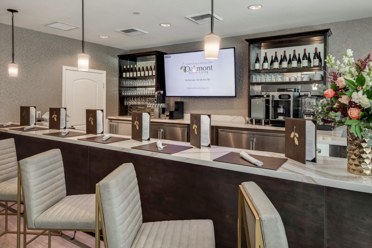 A modern bar and restaurant interior with elegant seating and a display of wine bottles.