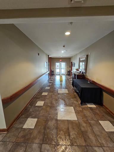 A well-lit hallway leading to an entrance with decorative tile flooring.
