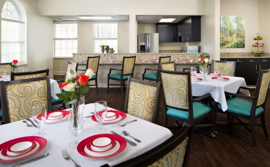 A stylish dining area with elegantly set tables, featuring vibrant decor and comfortable seating.