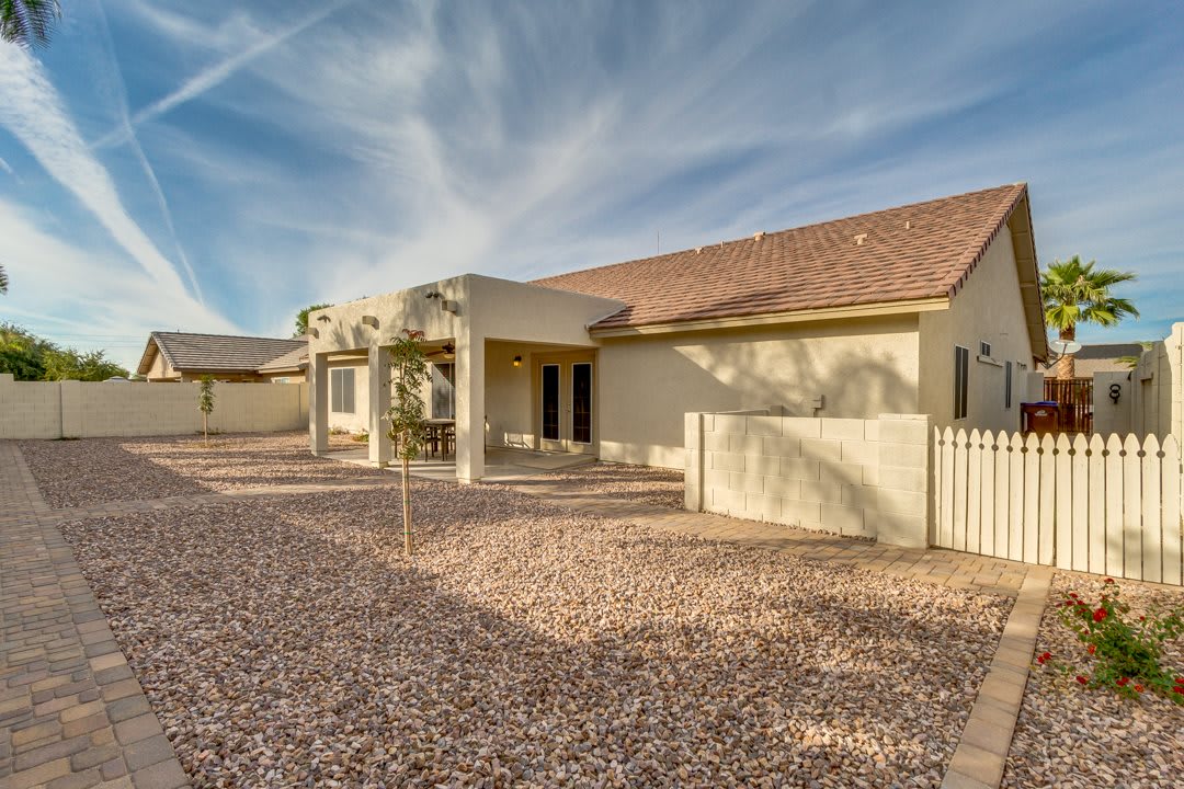 Single-story house with a covered patio in a desert landscape.