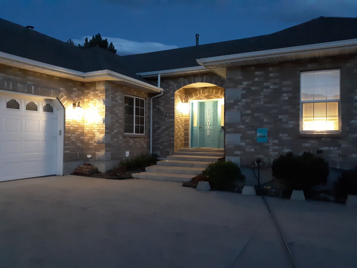 A brick house entrance warmly lit during the evening.