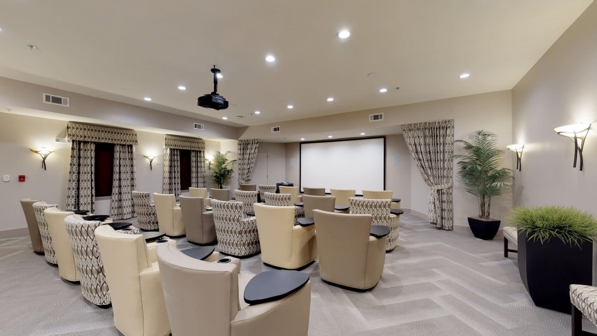 A luxurious home theater setup with comfortable recliner seats facing a large projection screen.