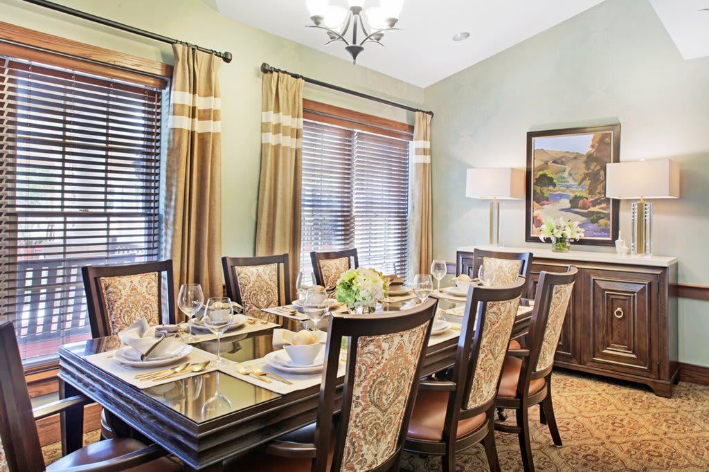A well-decorated dining room with an elegant table setting and warm lighting.
