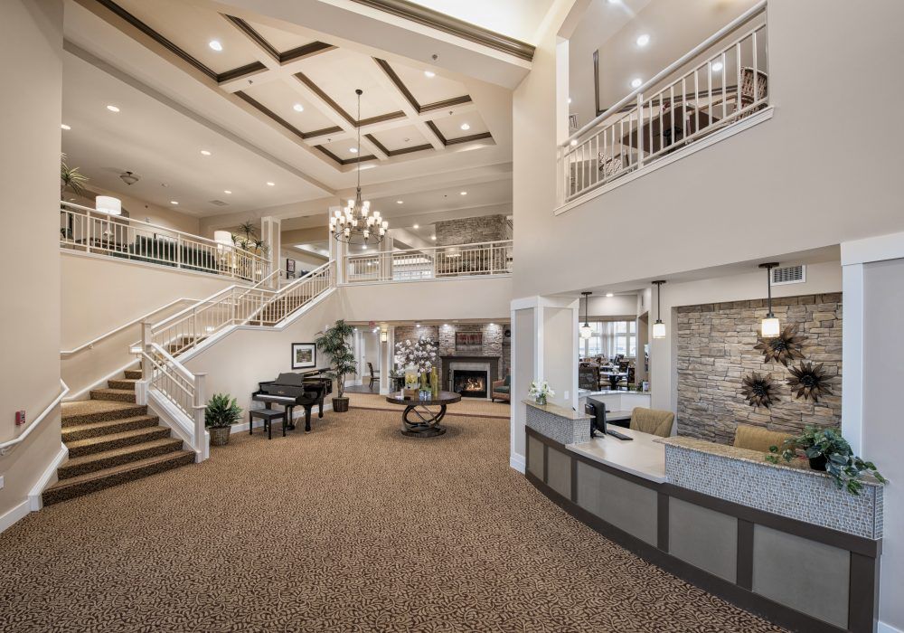 A spacious and elegantly designed lobby with a grand staircase and chandelier.