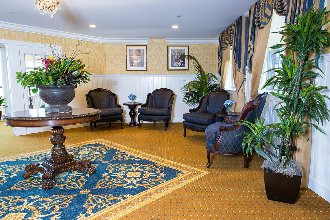 Elegant lobby seating area with classic furniture and lush plants.