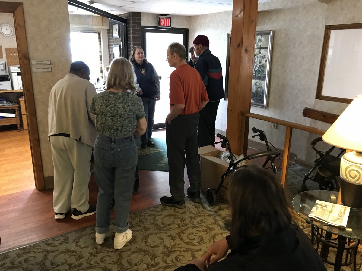 A group of people gathered near an entryway indoors.
