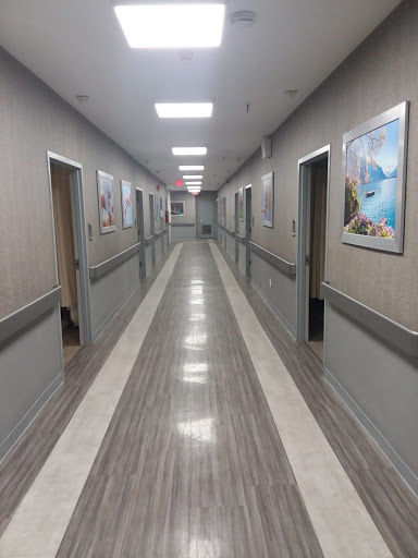 A long, well-lit corridor featuring multiple doors and decorative wall art.