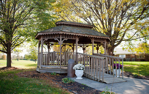 A charming wooden gazebo surrounded by autumn foliage, perfect for enjoying the outdoors.
