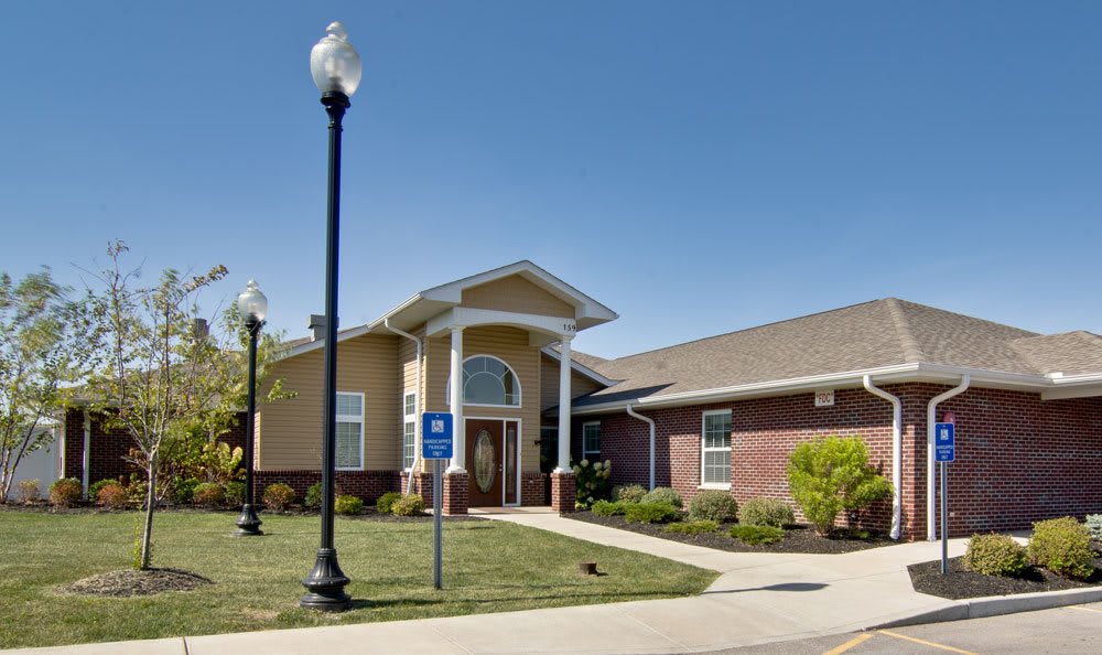 A brick building with a well-maintained lawn and clear blue sky overhead.
