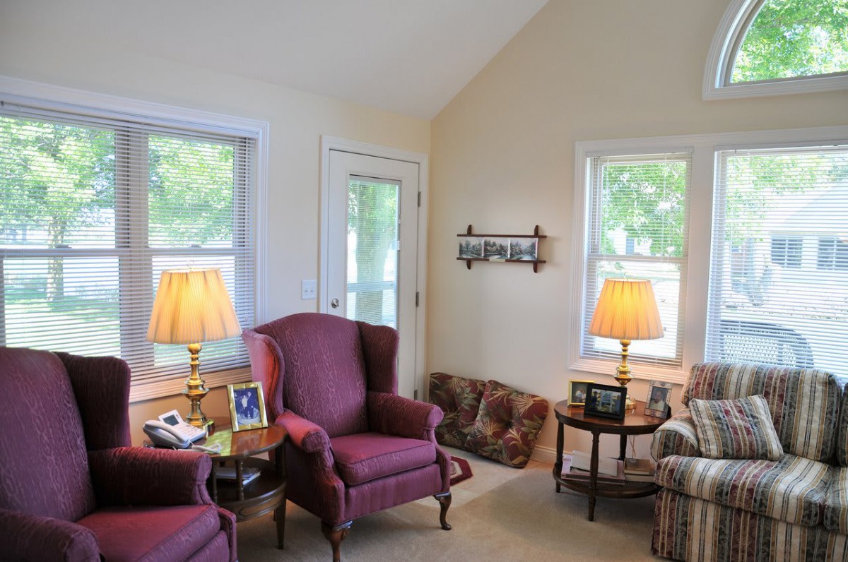A cozy living room with traditional decor, featuring armchairs and warm lighting.