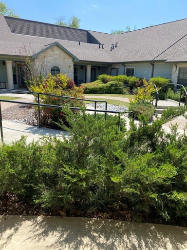 A well-maintained residential building surrounded by greenery.