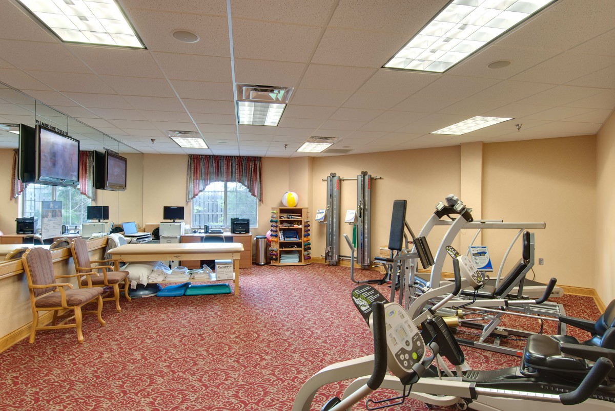 A spacious room equipped with fitness and therapy equipment, suggesting a gym or healthcare facility setting.