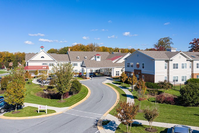 Aerial view of a residential complex with landscaped gardens and a winding road.
