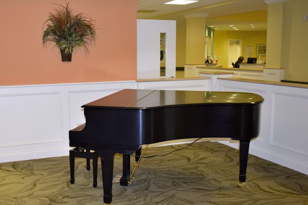 A black grand piano in an elegantly furnished room.