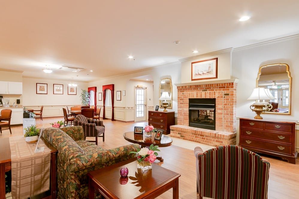 A cozy living room featuring a brick fireplace, comfortable seating, and warm decor.