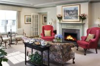 A cozy living room with a fireplace, comfortable seating, and traditional decor.
