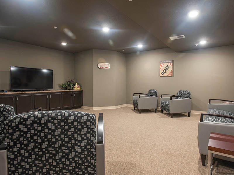A modern lounge area with chairs, a television, and neutral decor.