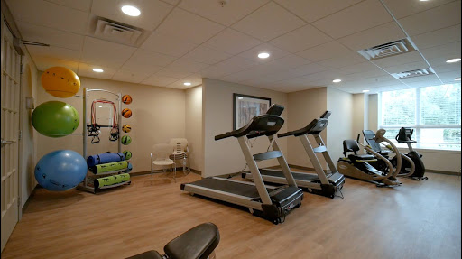 A well-equipped indoor gym featuring treadmills and workout stations.