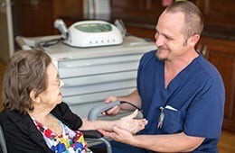 A healthcare professional interacting with an elderly patient.