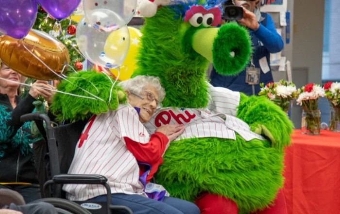 A joyful moment with a baseball mascot and an elderly fan.