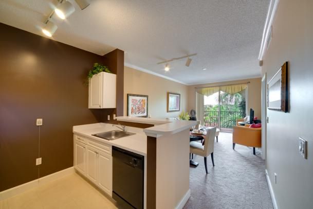 A modern apartment with an open kitchen and dining area, featuring sleek design elements.