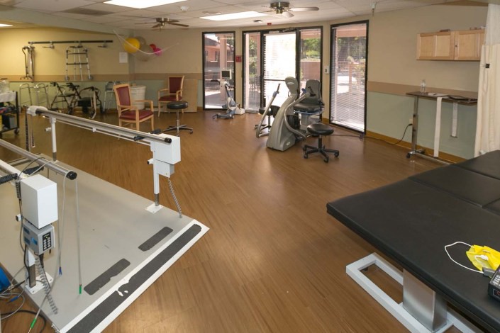 A physical therapy room equipped with rehabilitation equipment and exercise machines.