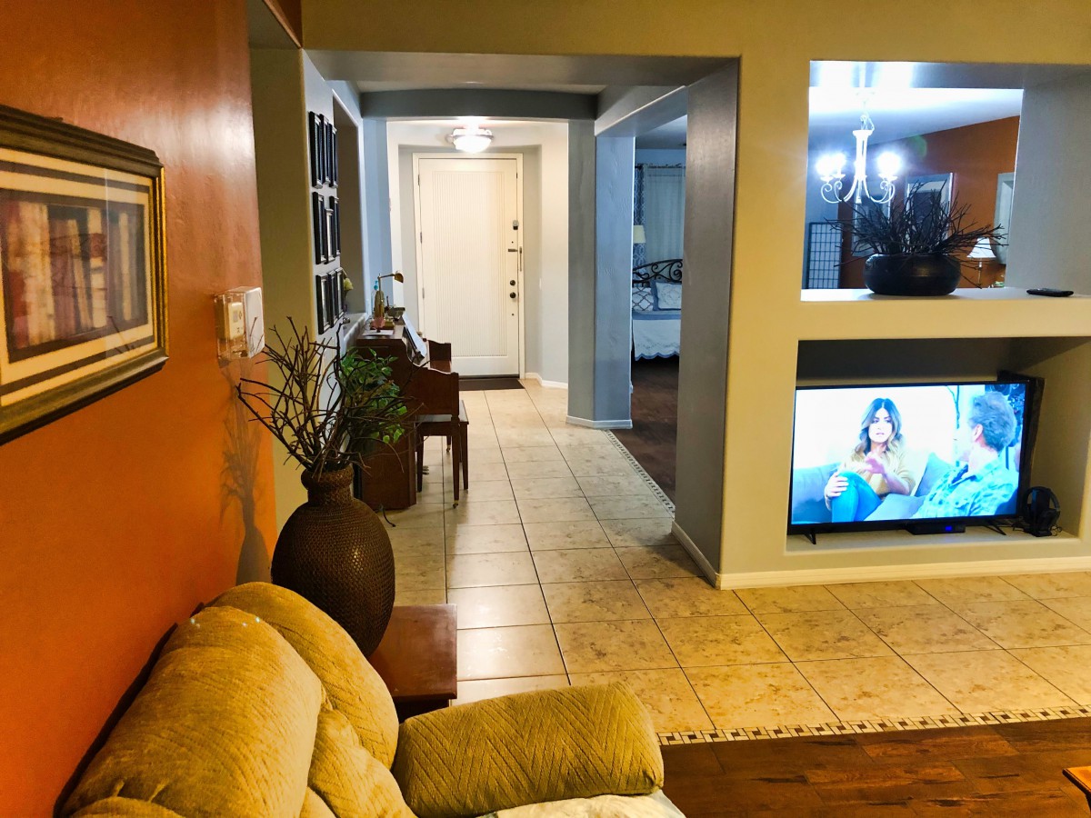 A cozy living room opens to a hallway with modern decor and soft lighting.