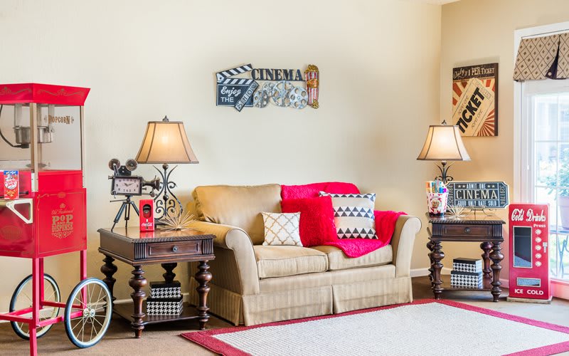 A cozy living room with a cinema theme, featuring a comfortable sofa flanked by two lamps and decorated with movie-related decor.