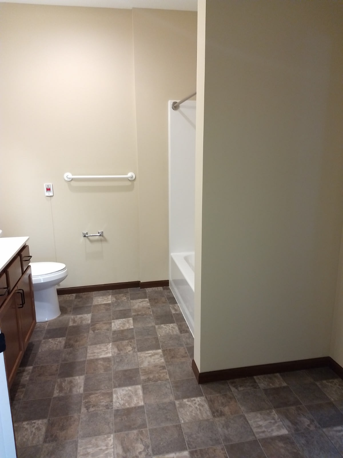 A clean and spacious bathroom with a toilet, bathtub, and sink.