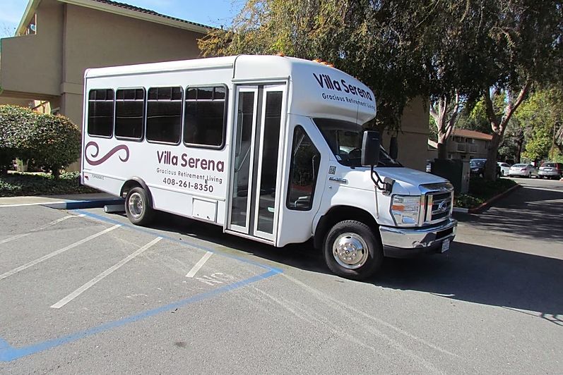 A white shuttle bus parked in an outdoor area.