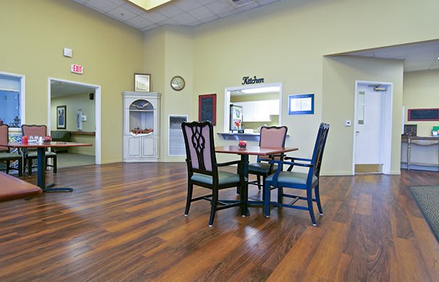 A cozy dining area with a wooden table and mismatched chairs on a polished wooden floor.