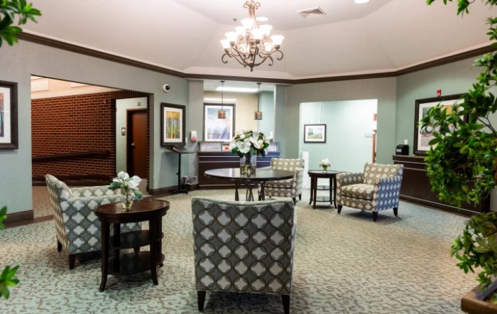 A cozy lobby area featuring comfortable seating, a chandelier, and elegant decor.