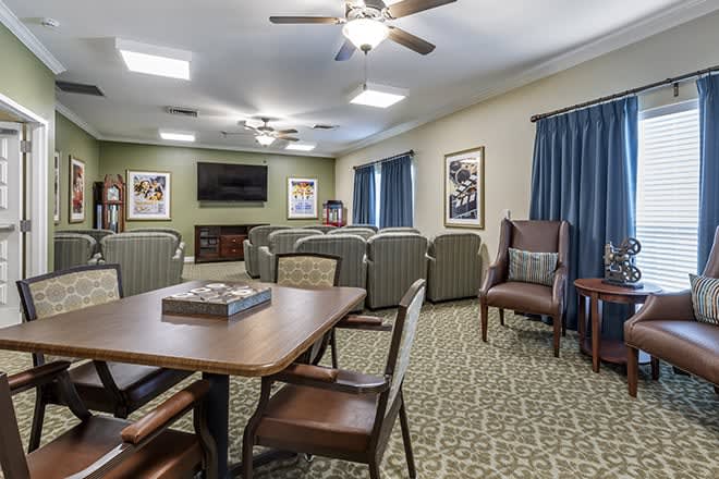 A cozy living room setup with comfortable chairs, a table, and a television.