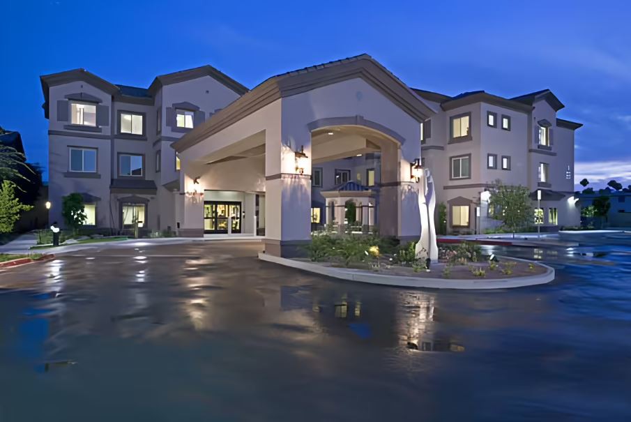 A well-lit hotel entrance at night, showcasing modern architecture.