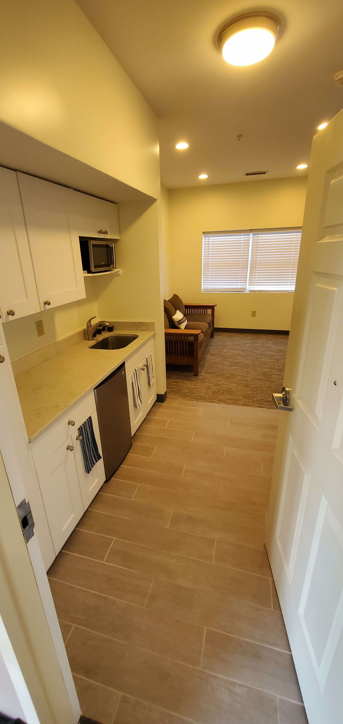 A small kitchenette leads to a cozy living area with seating.