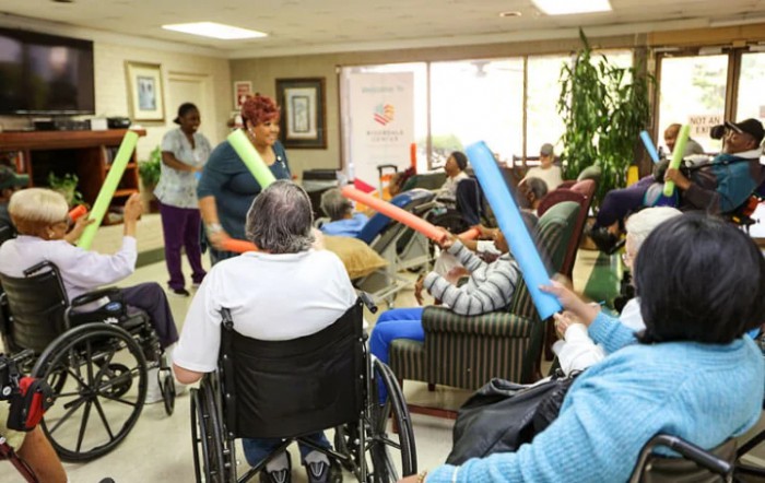 Residents in a care home participate in an indoor activity session.