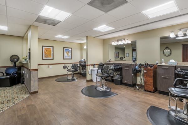 A modern barber shop interior with styling chairs and mirrors.