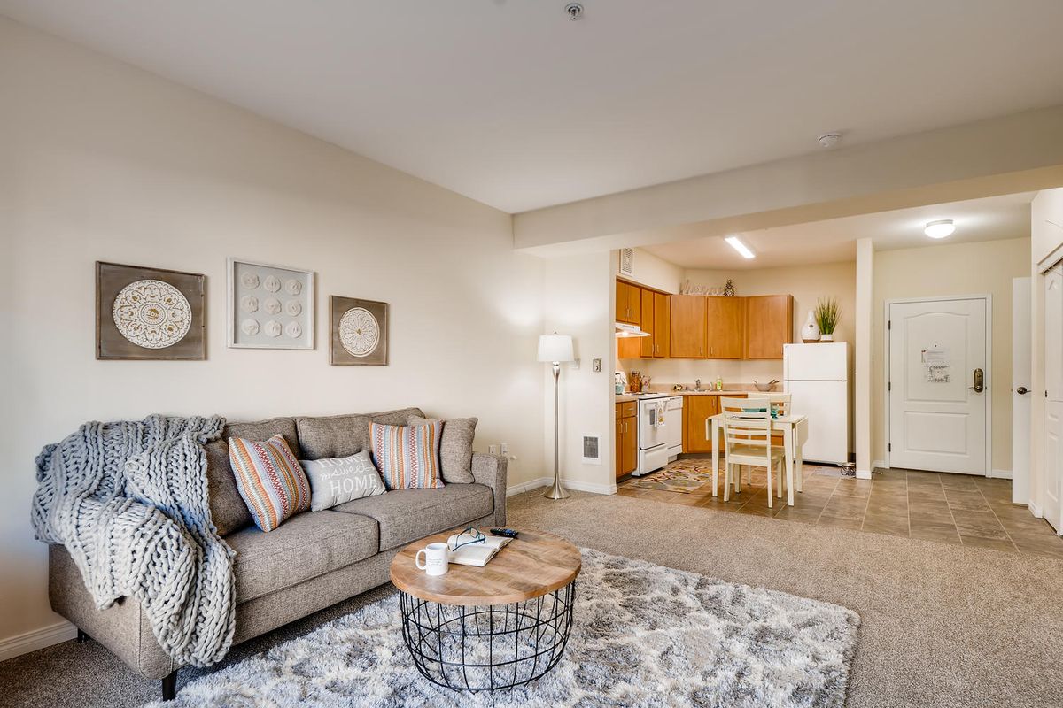 Cozy apartment living room with a view of the kitchen and dining area.