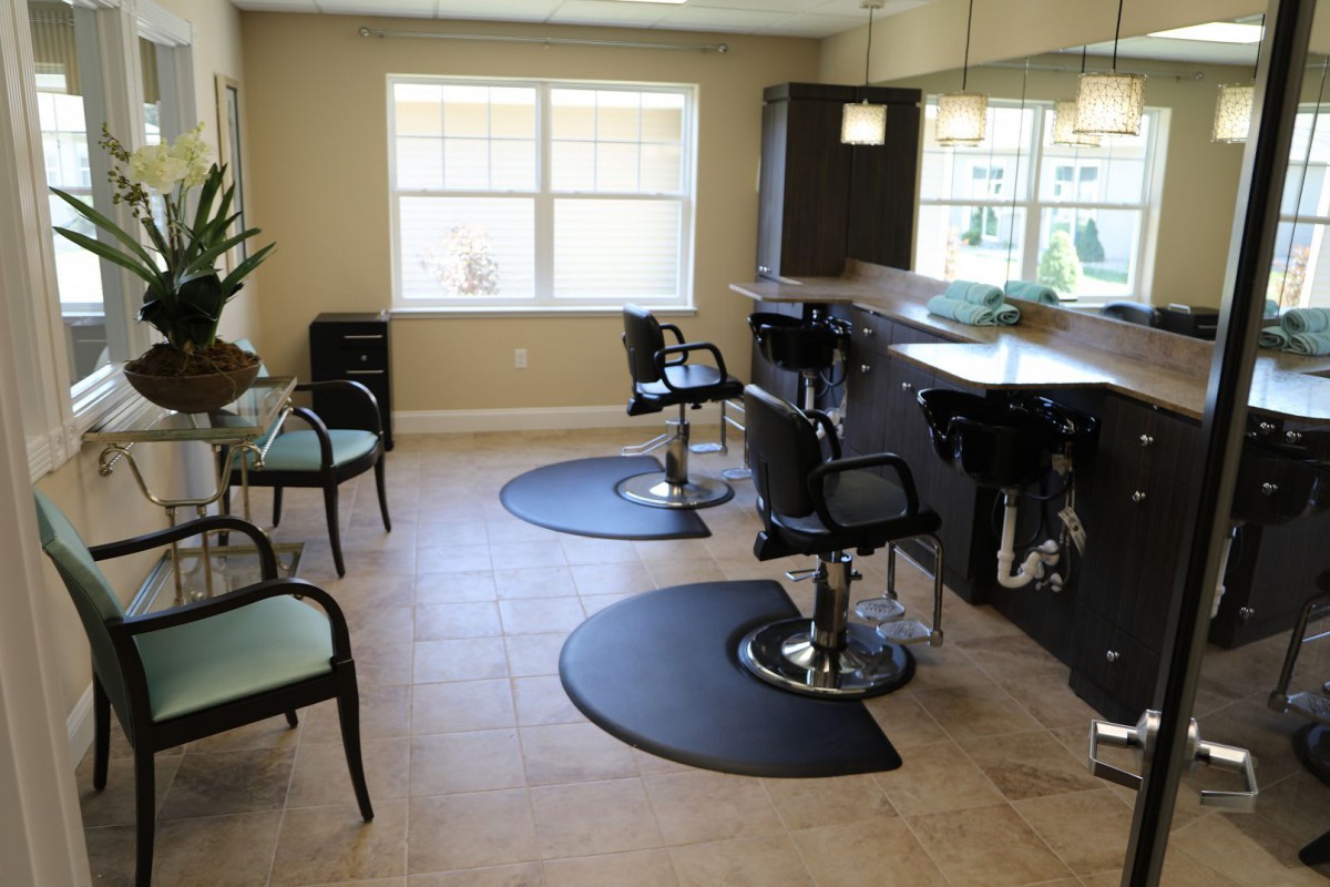A modern hair salon interior with styled chairs and workstations.