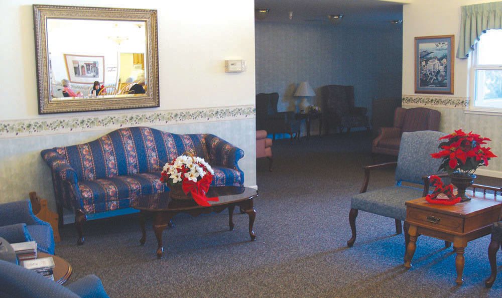 A cozy living room with a sofa, coffee table, and decorative flowers.
