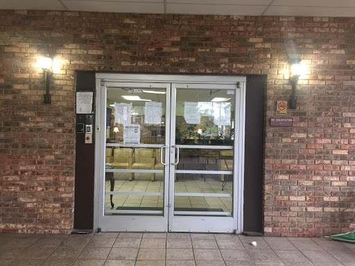 Main entrance with double glass doors featuring a brick facade.