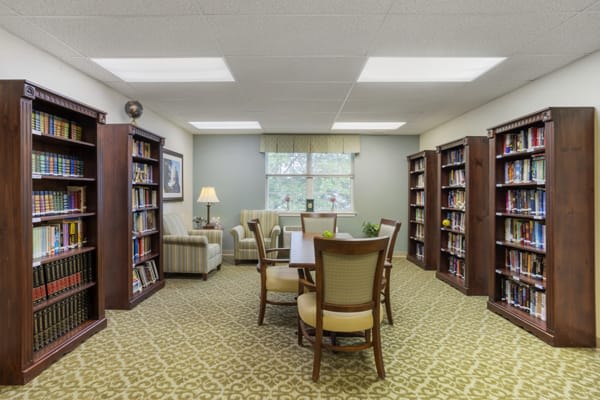 A cozy library room with bookshelves and a reading area.