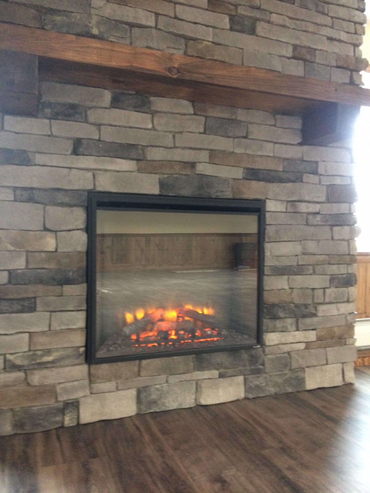 A stone fireplace with a cozy fire burning inside, adding warmth to the home's interior.