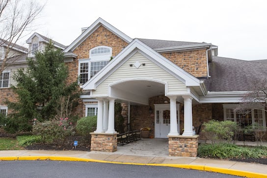 An exterior view of a building entrance with columns and brickwork.
